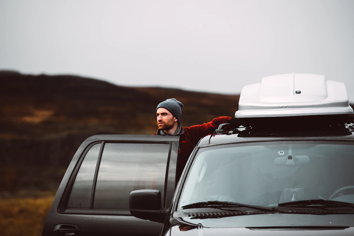 Car with a roof box on a road trip through open landscape